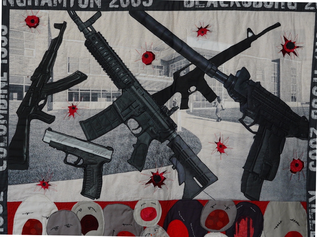 Close-up of guns, pistols and assault weapons near the top of the quilt